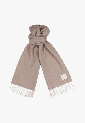Beige sjaal gemaakt van zacht materiaal, met een franjerand en een klein stoffen label aan één uiteinde, geknoopt ter exhibitie.