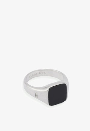 Bague en argent avec une pierre noire carrée en son centre, surface lisse et branding subtil à l'intérieur. Design moderne et minimaliste.