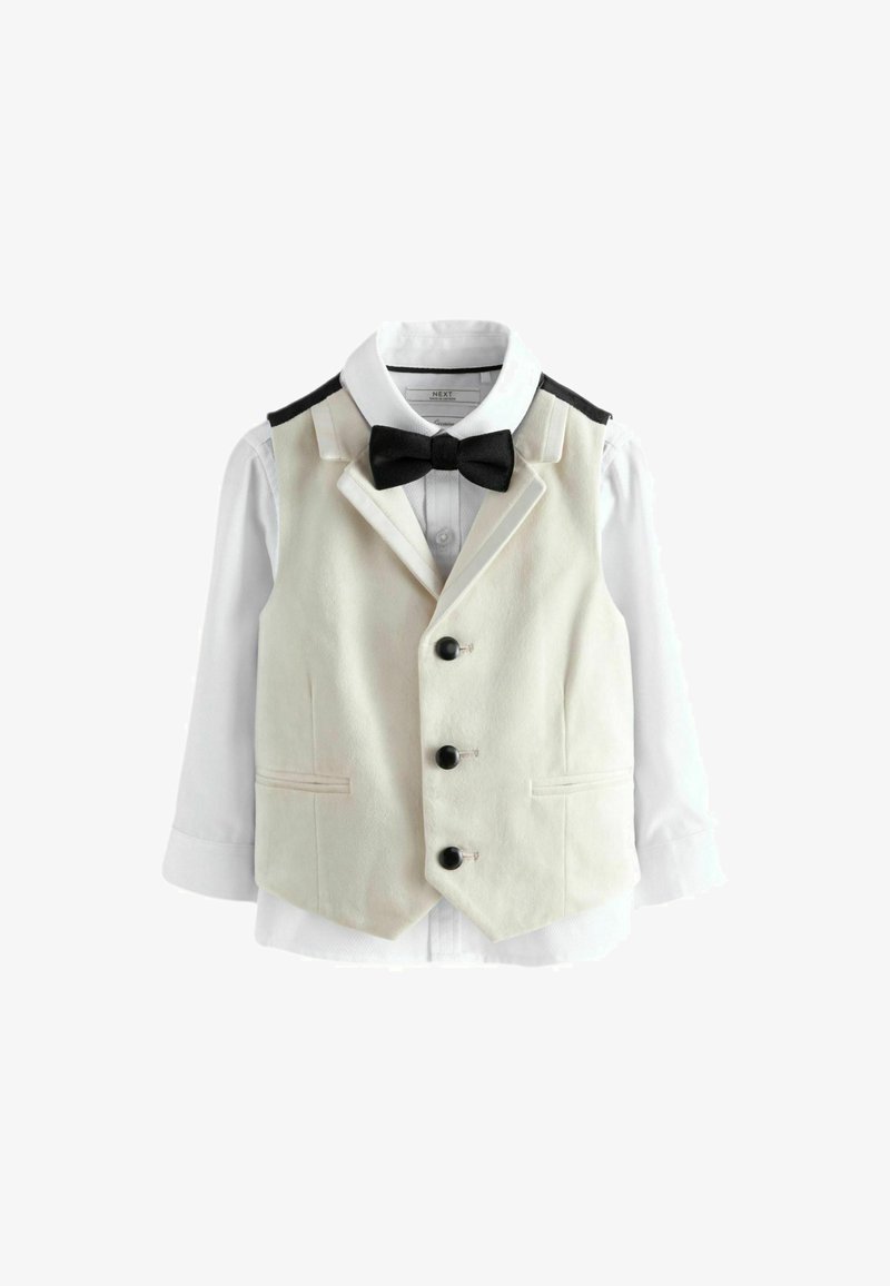 Gilet de smoking pour enfants en crème, avec un nœud papillon noir, des accents noirs aux épaules et des boutons noirs. Comprend une chemise blanche attachée.