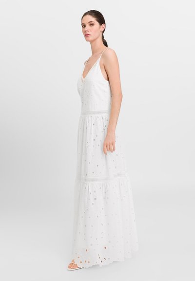 Rochie maxi albă din bumbac brodat, cu decolteu adânc în V, bretele subțiri și design stratificat, având decupaje circulare.