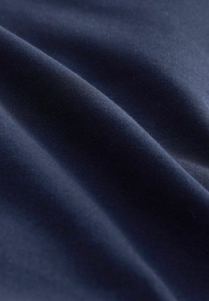 Tessuto blu scuro con una consistenza liscia, caratterizzato da morbide pieghe e un leggero lucido, che evidenzia i drappeggi e il gioco di ombre.