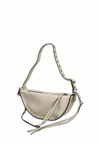 Borsa in pelle beige strutturata con profili neri a contrasto. Presenta una forma curvata, una tracolla regolabile con borchie metalliche e una chiusura con zip.