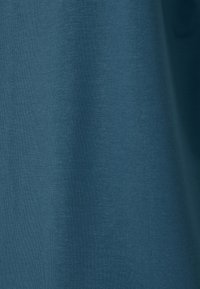 Turkusowa bawełniana tkanina o gładkiej fakturze i subtelnym prążkowanym wzorze, prezentująca jednolitą kolorystykę bez widocznych szwów czy ozdób.