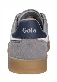 Sneakers in suede grigio con un accento in pelle bianca e una linguetta sul tallone di colore blu scuro. Presentano una suola in gomma e il marchio Gola sul tallone.