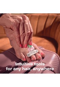 Une main tenant un petit rasoir rose et vert coupant les ongles des orteils vernis en rose vif, reposant sur une valise rose.