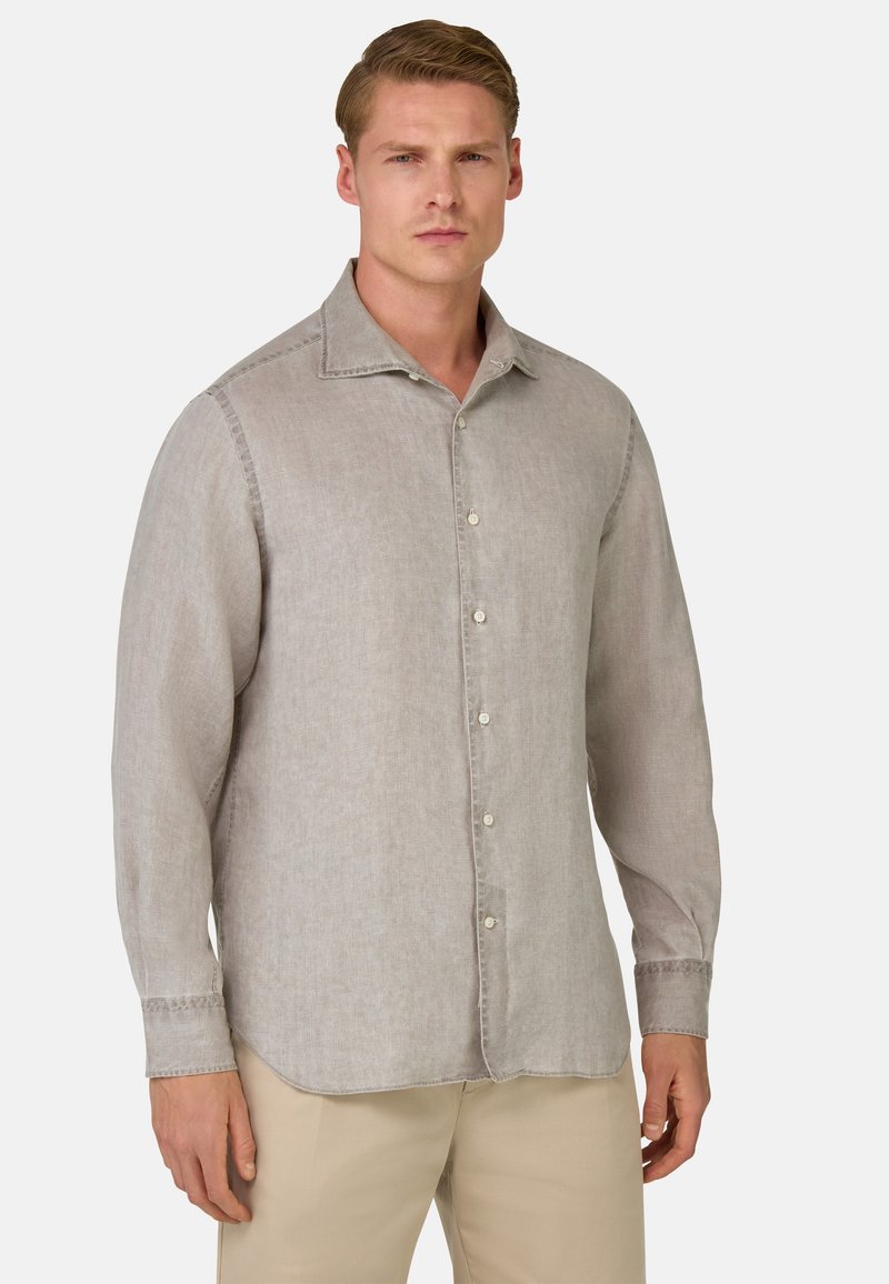Camicia di lino grigio chiaro a maniche lunghe, con colletto appuntito e chiusura a bottoni; presenta una sottile texture e cuciture a contrasto.