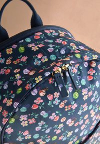 Virágmintás hátizsák tartós anyagból, sötétkék alapon, arany cipzárbútorzattal és texturált felületi részletekkel.