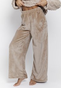 Beige, zachte fleece loungebroeken met een elastische tailleband, wijde pijpen en een gladde textuur, die een ontspannen pasvorm en comfort bieden.