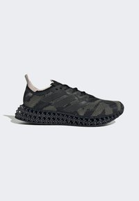 Zapatilla negra y beige con cordones, de parte superior de punto y suela de rejilla impresa en 3D, mostrada de perfil lateral sobre fondo gris.