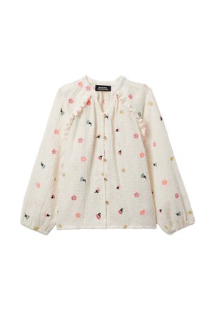 Blouse blanche à manches longues avec bordure à volants, boutonnage frontal, et petit motif de broderie florale en rose, jaune et noir.