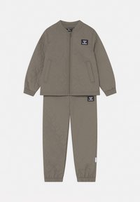 Quiltet olivengrøn børnejakke og matchende bukser med frontlynlås, sidelommer, elastiske manchetter og hummel-logoer på både jakken og bukserne.