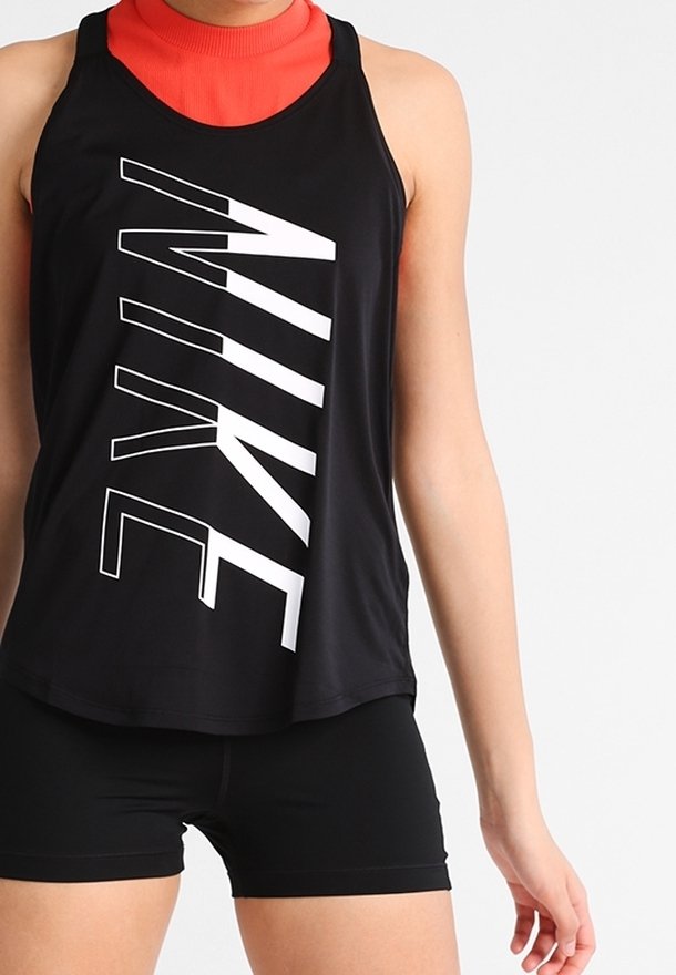 Schwarzes Sport-Tanktop mit großem weißen "NIKE"-Logo, ärmelloses Design, glattes Material, getragen über einem roten Oberteil mit hohem Kragen, kombiniert mit schwarzen Shorts.