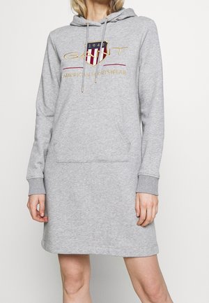 Vestido tipo sudadera con capucha de manga larga en gris claro, con bolsillo delantero y logo de GANT que presenta un escudo rojo, blanco y azul con el texto "1949" y "American Sportswear".