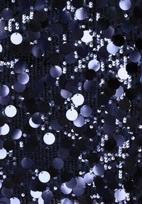 Tessuto blu scuro densamente decorato con paillettes lucenti sovrapposte e grandi dischi metallici rotondi che creano una superficie scintillante e testurizzata.