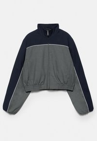 Veste courte à fermeture éclair avec col montant, taille élastique et manches longues en bleu foncé et gris avec des détails de passepoil blanc.