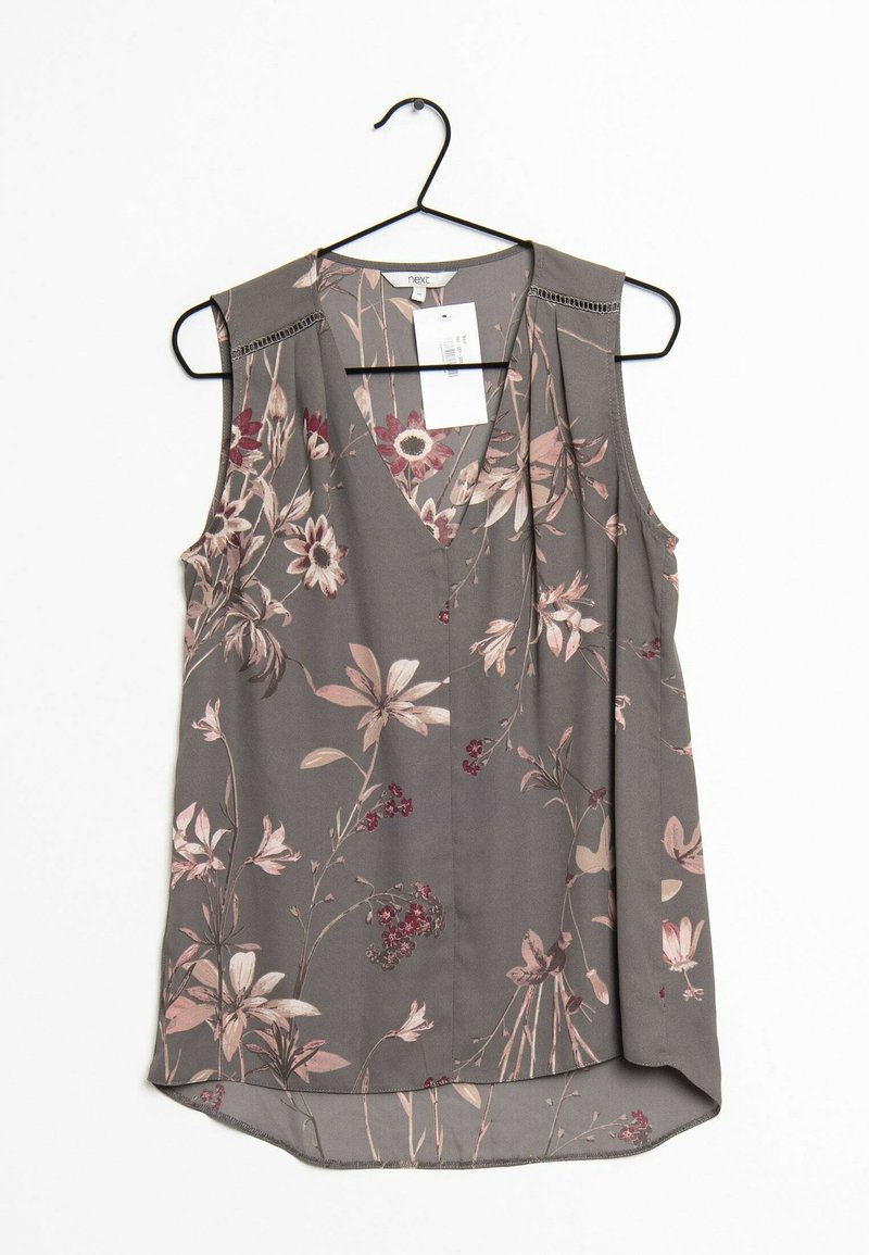 Blouse sans manches en tissu gris, avec un col en V, des motifs floraux délicats en rose et bordeaux, un ourlet arrondi et de légers plis.