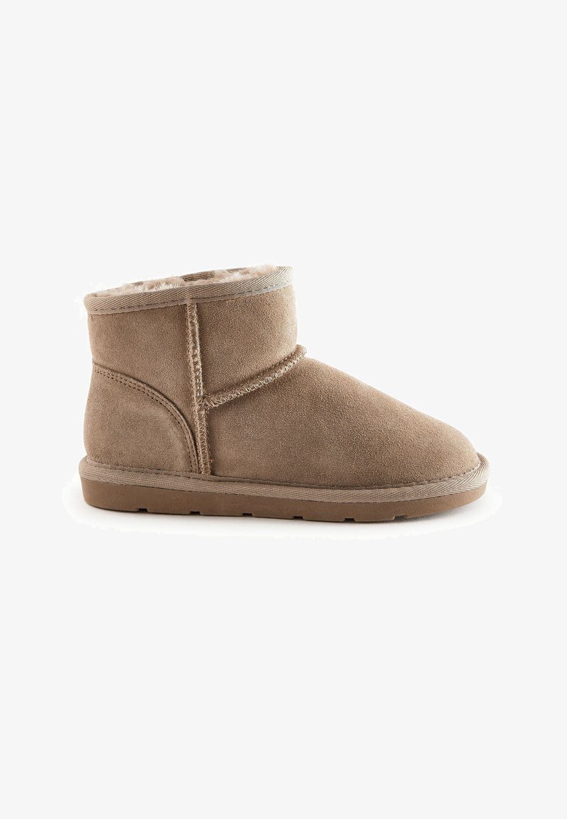 Ghete ankle din suede bej, cu o căptușeală moale, vârf rotund și talpă din cauciuc plat. Prezintă detalii cusute și un vârf cu revenire.