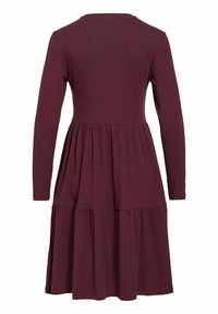 Robe manches longues couleur lie de vin avec un corsage cintré et une jupe à volants, dotée d'un col rond et d'un tissu texturé.