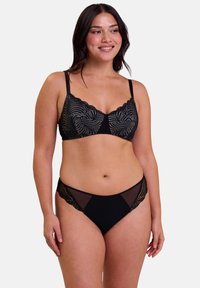 Ensemble de lingerie noire avec des détails en dentelle festonnée, des accents en maille et un soutien-gorge à armatures. La bande sans coutures offre confort et finition lisse.
