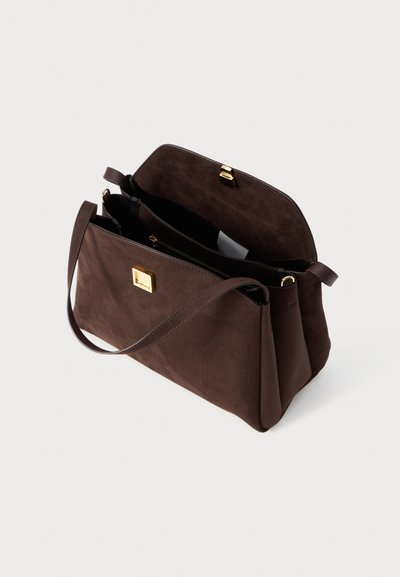 Geantă din suede maro cu două compartimente, un închizător aurit și o curea lungă pentru purtare. Textură netedă cu un design structurat.