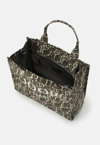 Bolso tote de patrón verde con doble asa, que cuenta con un bolsillo con cremallera en el interior y un gran texto blanco en el exterior. Textura de tela suave.