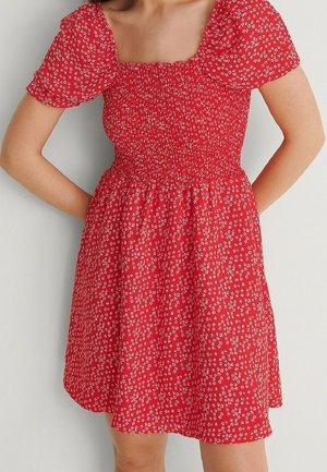 Red floral dress with puff sleeves, square neckline, and elastic smocking at the bodice. Features a tiered skirt and small white flower pattern.