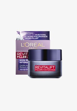 Crème L'Oréal Revitalift Filler dans un pot rond gris foncé avec un couvercle violet. La boîte présente des graphismes blancs et violets avec du texte rouge.