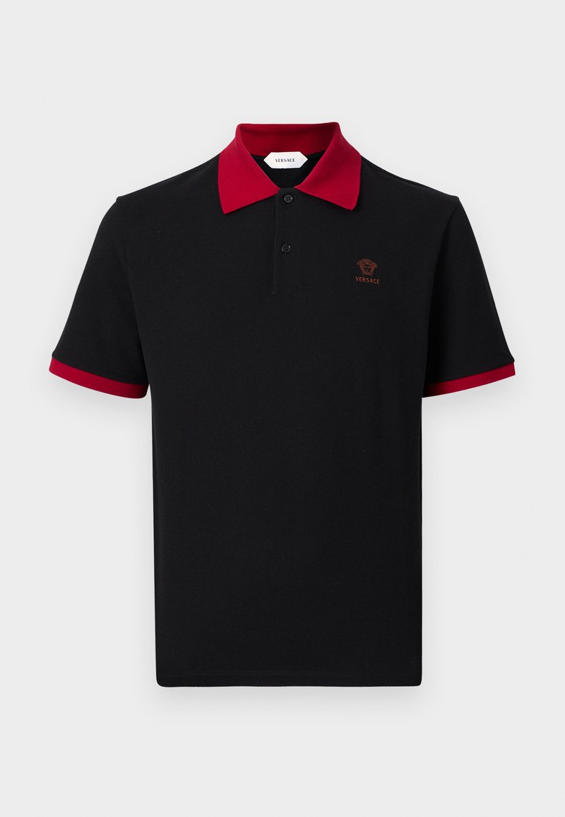 Black polo shirt with red collar and sleeve edges, two-button placket, and small brown Versace Medusa logo on left chest.
