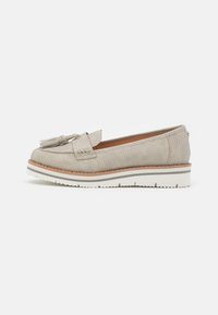 Light beige leather loafers with a textured pattern, featuring a bow accent, and a chunky white rubber sole with a brown trim.