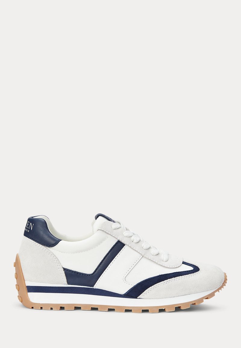 Adidași din piele albă și suede bleumarin, accentuați cu un design geometric și o talpă din cauciuc texturat pentru aderență.