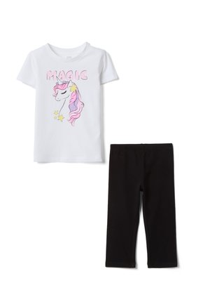 Camiseta blanca de manga corta con gráfico de unicornio rosa y estrellas amarillas y texto "MAGIC", combinada con leggings negros de largo medio.