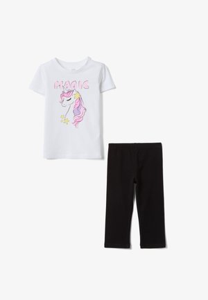 Camiseta blanca de manga corta con gráfico de unicornio rosa y estrellas amarillas y texto "MAGIC", combinada con leggings negros de largo medio.