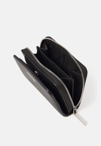 Black leather wallet with three compartments, silver zipper closure, and a silver hardware tag. Interior lined with black fabric.