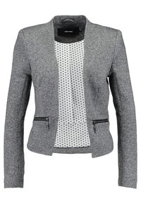 Blazer cintré gris texturé avec deux poches zippées et un panneau intérieur blanc à pois sur le devant.
