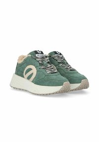 Green suede sneakers with a textured cream outsole, featuring black and white patterned laces and a prominent beige logo detail.