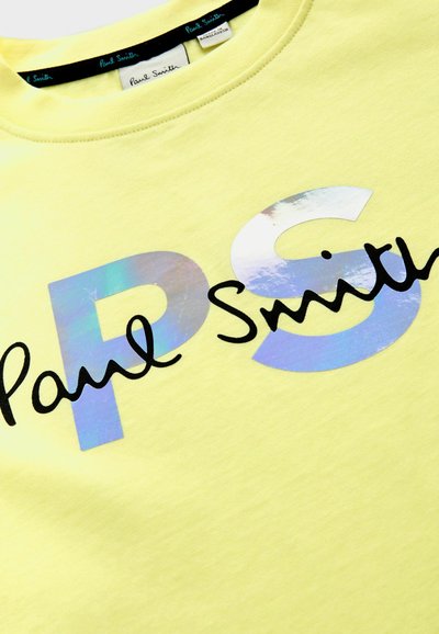 Sudadera de algodón amarilla con un brillante logo holográfico "PS" y texto cursivo en negro "Paul Smith". Cuello redondo y textura suave.