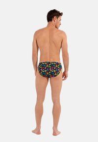 Herren-Schwimmunterhosen mit einem mehrfarbigen Schmetterlingsmuster auf schwarzem Hintergrund. Das Design zeichnet sich durch eine enganliegende Form und einen glatten Stoff aus.