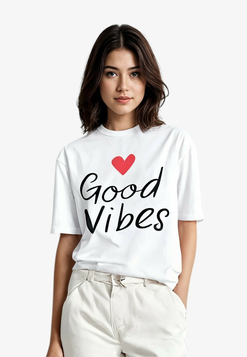 Witte katoenen T-shirt met "Good Vibes" in vette zwarte letters en een rode hart, korte mouwen en een losse pasvorm.