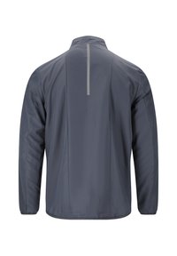 Harmaa kevyt takki, jossa on pystykaulus ja pitkät hihat. Takana on heijastava pystysuuntainen raita näkyvyyden parantamiseksi.