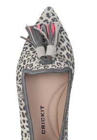 Scarpa a punta con stampa animale grigia e bianca, in pelle texturizzata, e con nappine decorative grigie e rosa davanti.