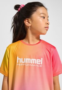 Kortärmad gradiente T-shirt i gul till rosa, med "hummel PERFORMANCE"-logotyp i vitt, tillverkad av ett glatt, lätt material.