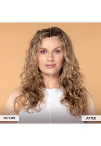 Przemiana fryzury przed i po, przedstawiająca faliste, sięgające do ramion włosy w blond odcieniach, z wyraźną objętością i definicją. Tło jest w neutralnym beżowym kolorze.