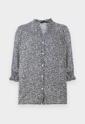 Blouse bleu marine avec un motif léopard, fermeture à boutons et manches 3/4 avec des poignets froncés. Fabriquée en tissu léger.