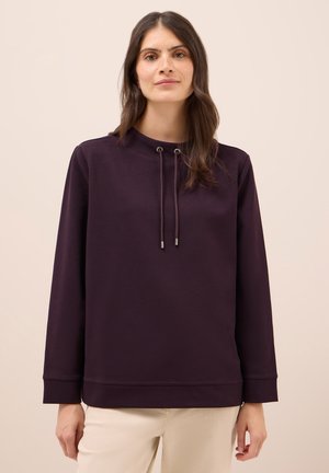 Sweatshirt violet foncé avec un col haut, des accents à cordon de serrage et des manches longues. Tissu doux, coupe décontractée, poignets et ourlet côtelés.