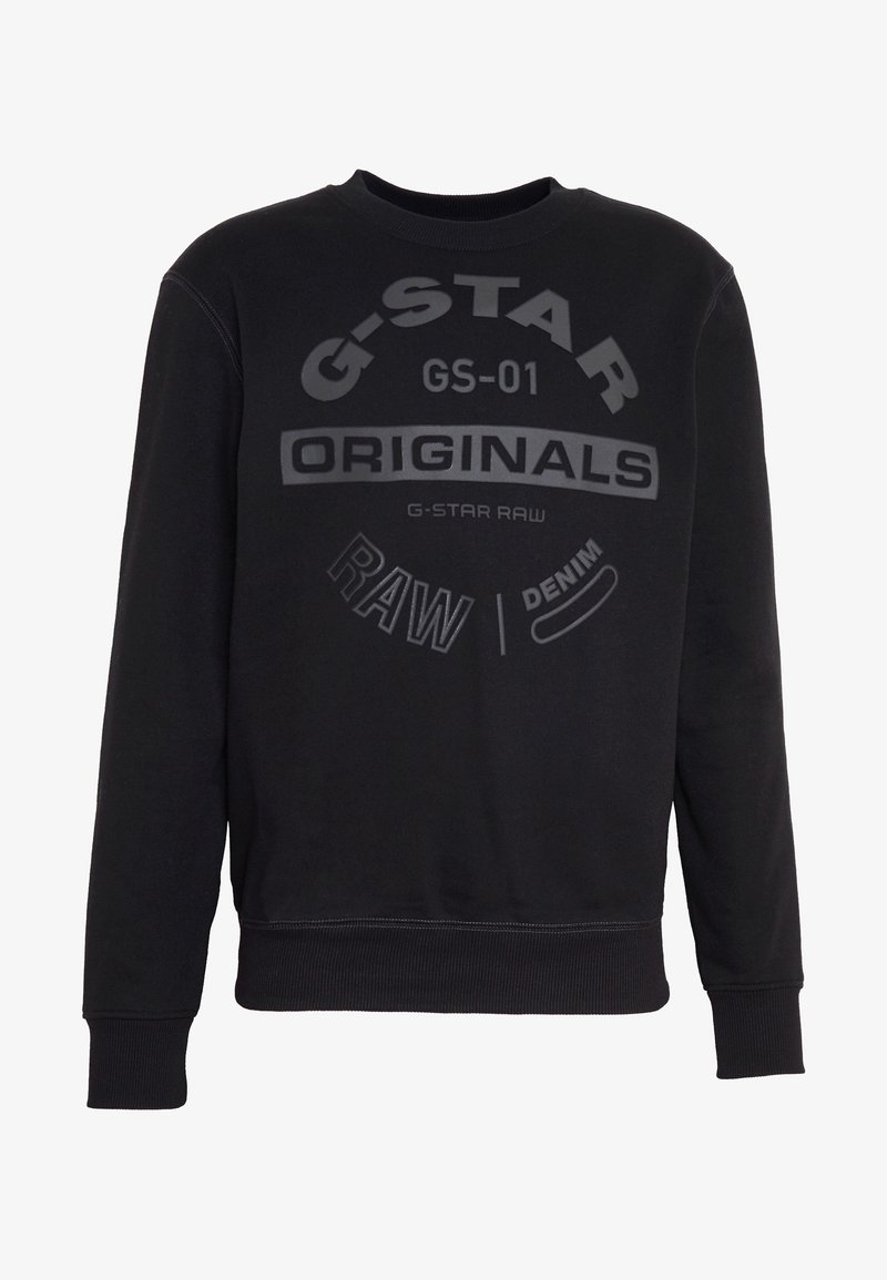 Sweat-shirt noir à manches longues avec poignets et ourlet côtelés, arborant le texte « G-STAR ORIGINALS RAW DENIM » imprimé en polices variées sur la poitrine.