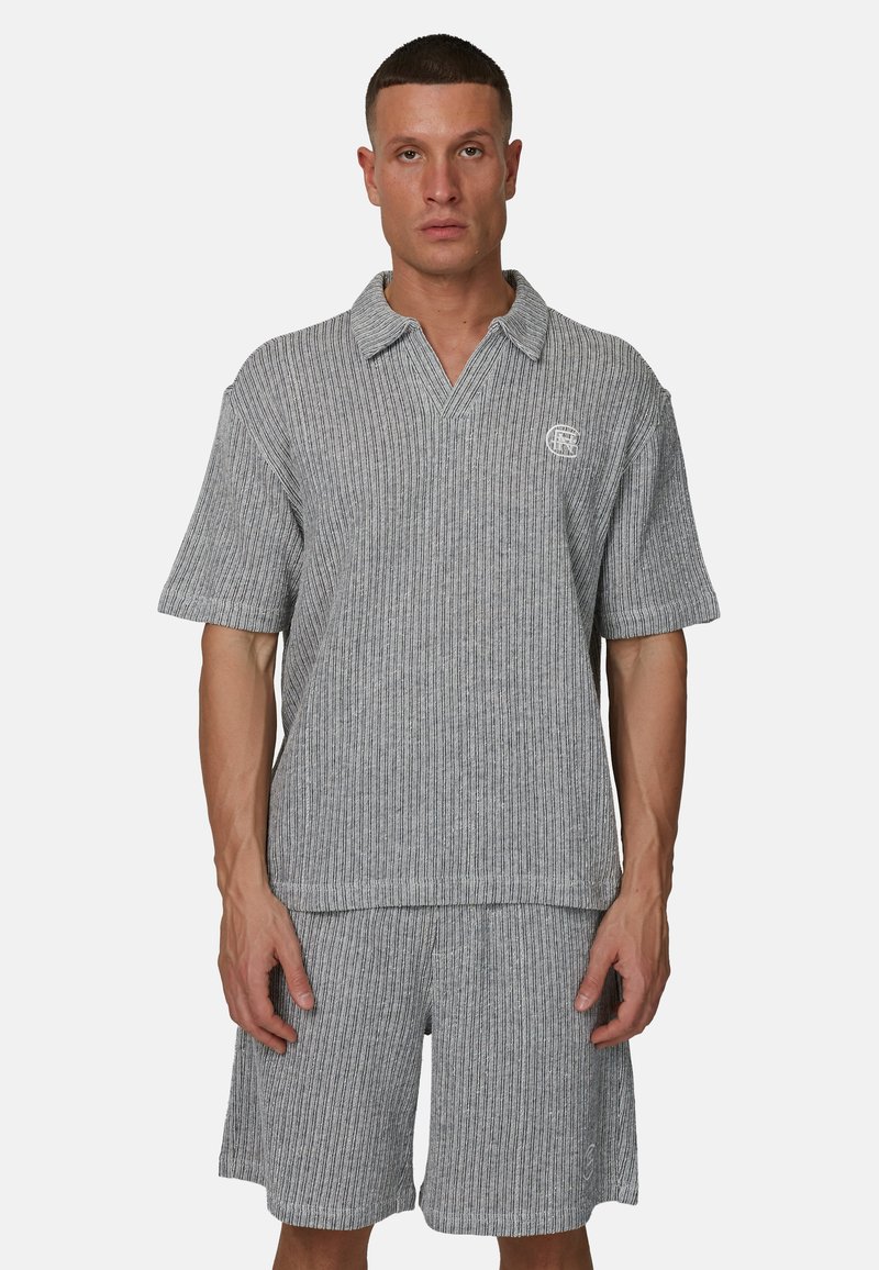 Polo à manches courtes en maille rayée grise avec un col en V et un détail logo, assorti à un short, les deux en tissu texturé.