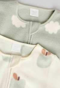 Två babyfleeceplagg, ett i ljusgrön med molnmönster och ett annat i krämfärg med abstrakta färgade former. Båda har runda halsringningar.