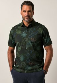 Tummanvihreä polo-paita, jossa on lehtikuvio sinisen, vihre�än ja punaisen sävyissä, varustettuna kauluksella ja lyhyillä hihoilla. Pehmeä kangas, rennon istuvuus.