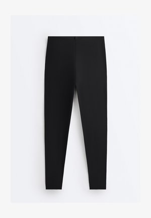 Črne oprijete pajkice z visokim pasom in gladkim materialom, prikazane na ravni površini na belem ozadju.