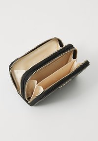 Zwarte portefeuille met rits en een gestructureerde buitenkant, met beige interne compartimenten en accenten. Bevat meerdere vakken voor organisatie.